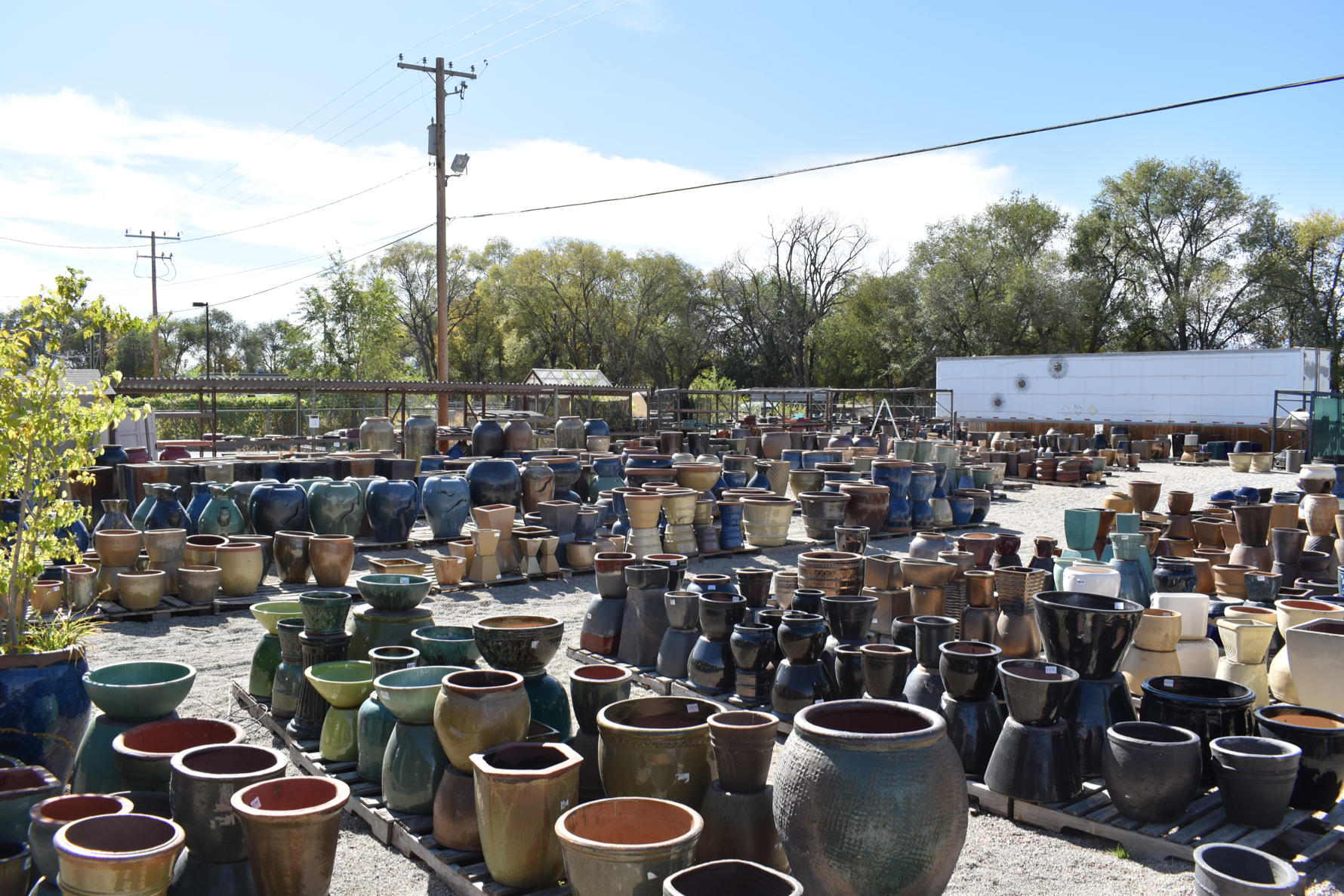 hundreds of ceramic pots stacked on pallets in our sandy retail lot